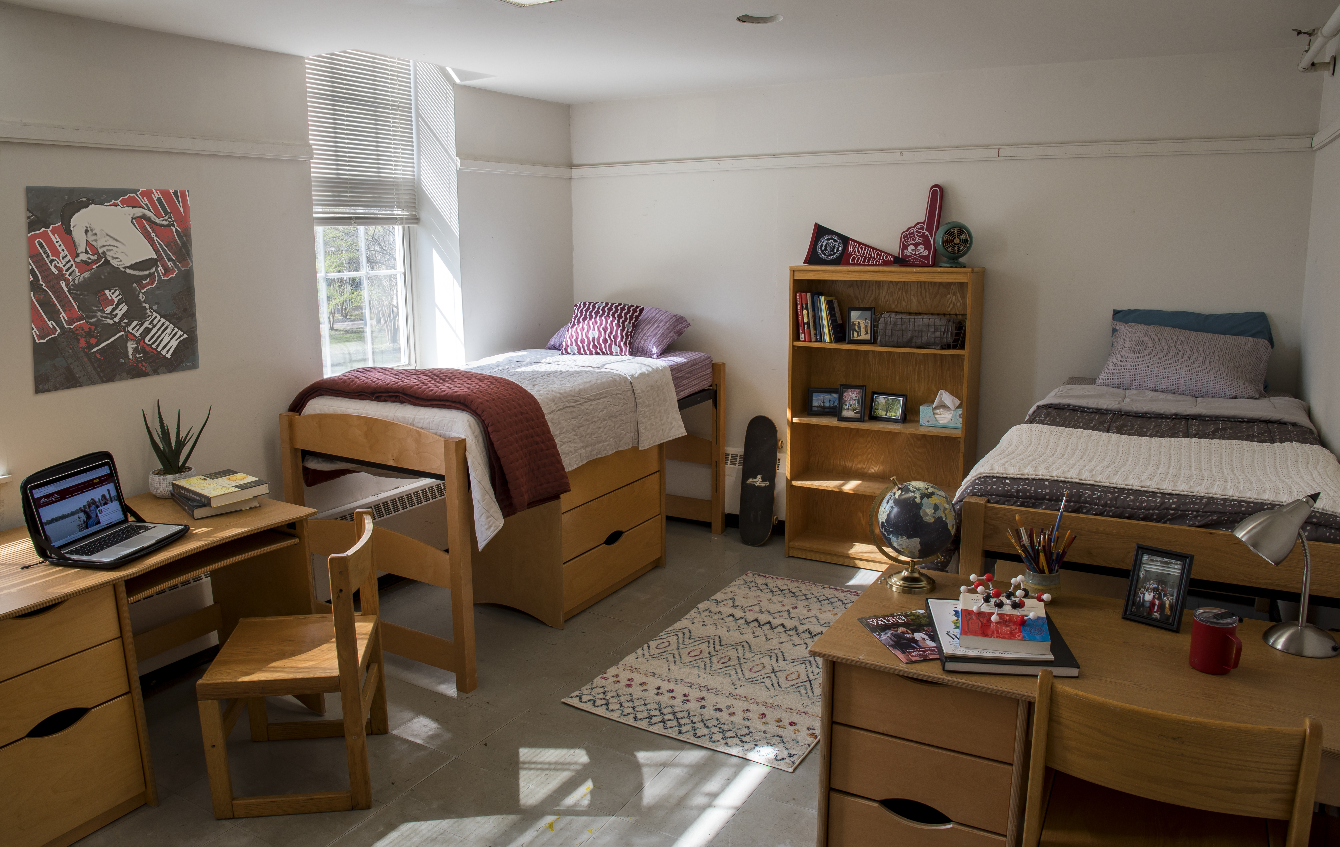 two beds, two dressers, two desks, window to left