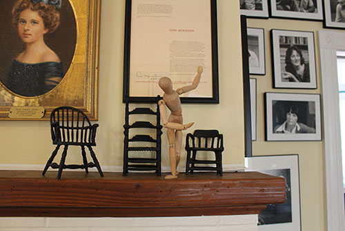 Wooden sculpture posed on wooden mantle in Literary House