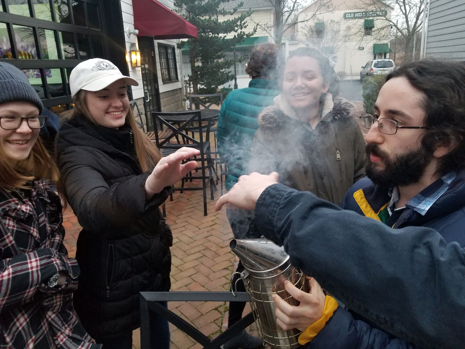 Demonstrating how to use a smoker for hive inspections