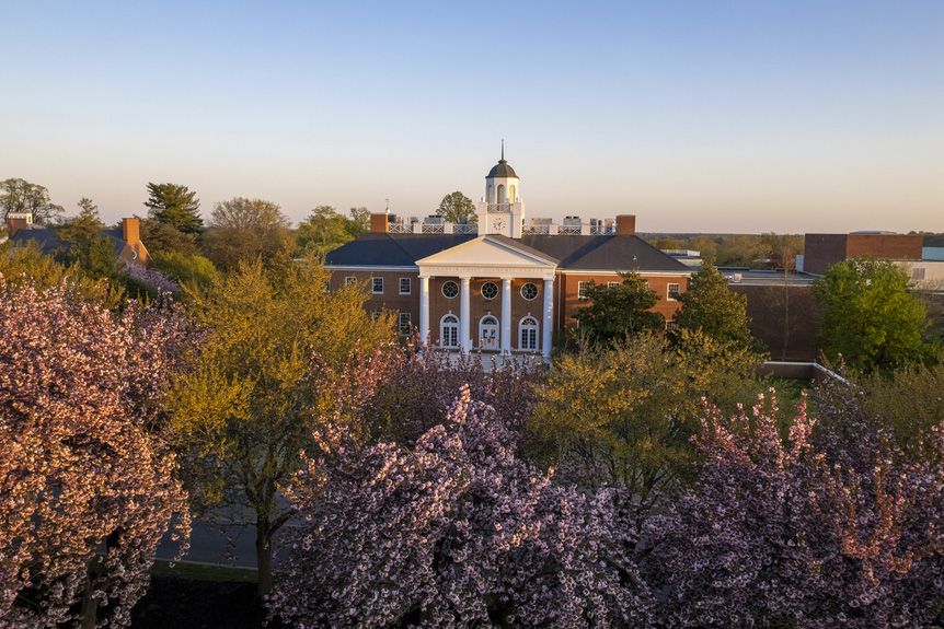 Casey Academic Center seen from the air behind flowering cherry trees