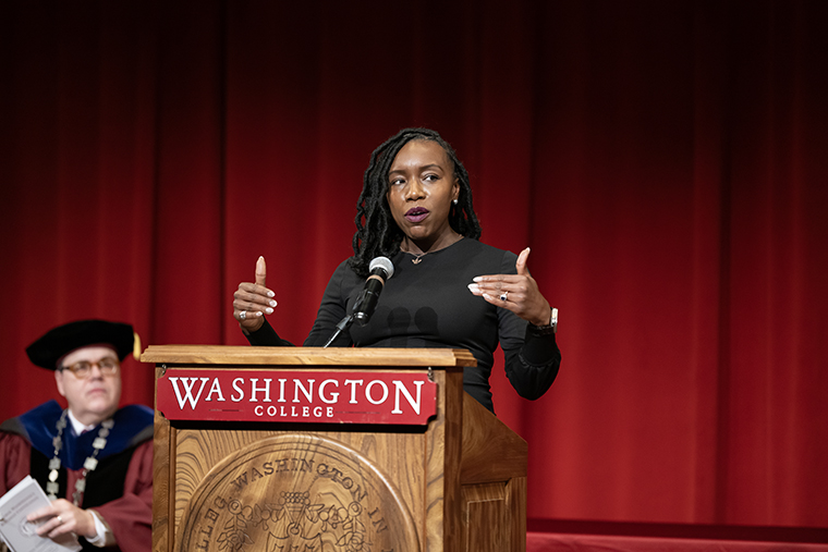 Caryn York speaks from behind the Washington College podium as President Mike Sosulski looks on.