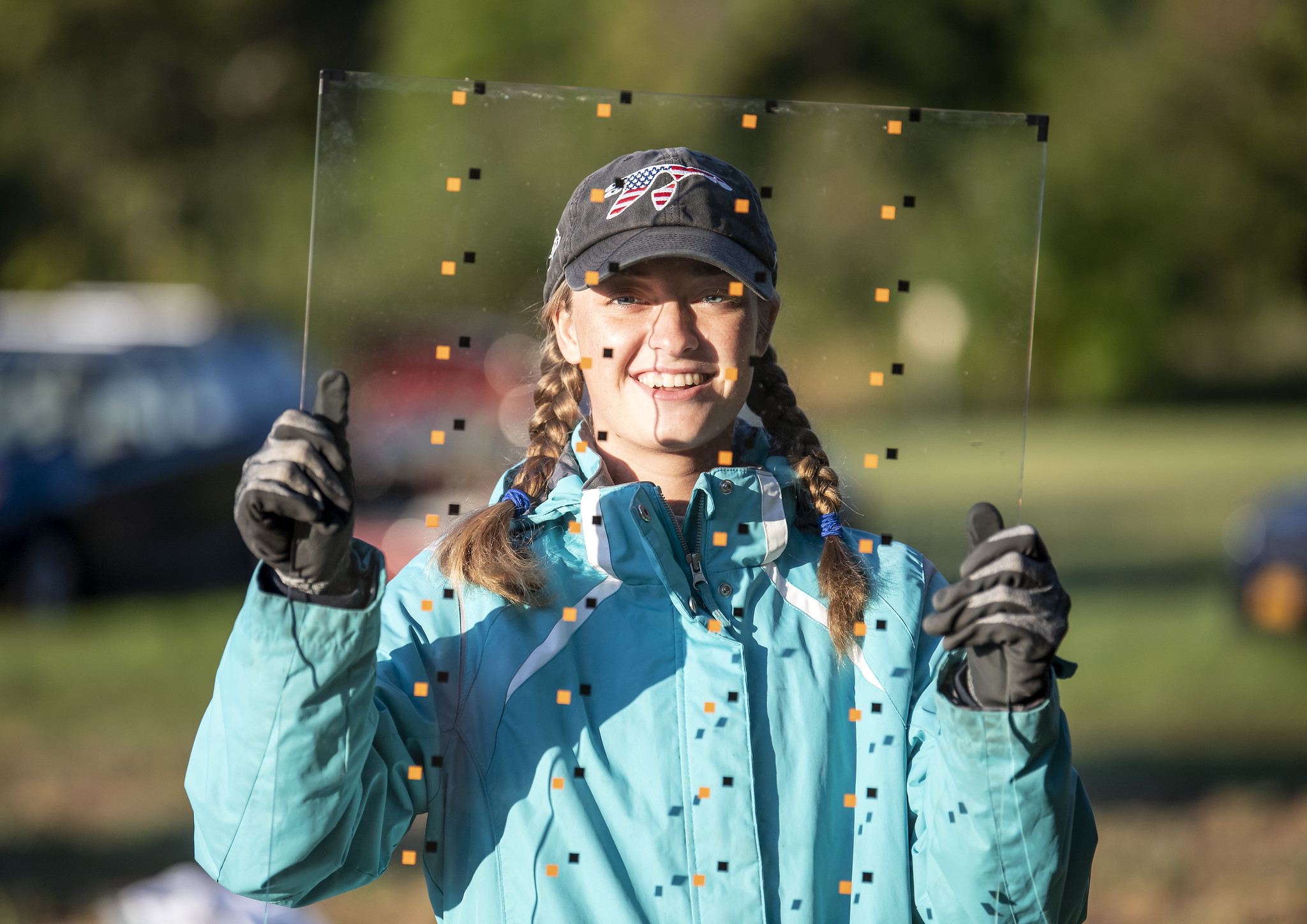 Meghan McHenry holds up a glass sample at the glass testing tunnel