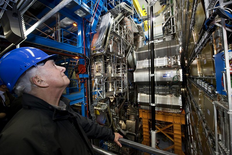 Peter Higgs looks up at ATLAS experiment equipment.