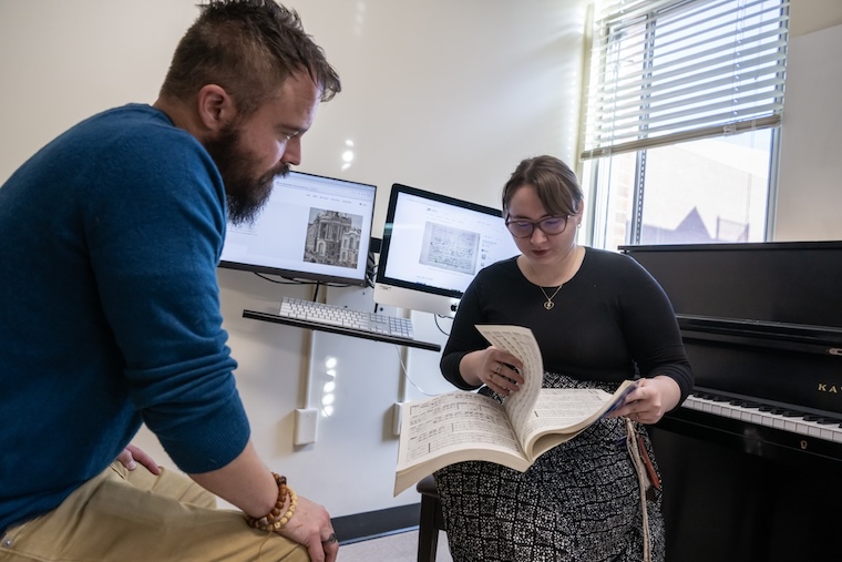 Dr. Jon McCollum and his student, Kaitlyn McCaffery, look over sheet music in a Washington College music room.