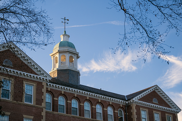 The roofline of Smith Hall set against a blue sky with wispy clouds