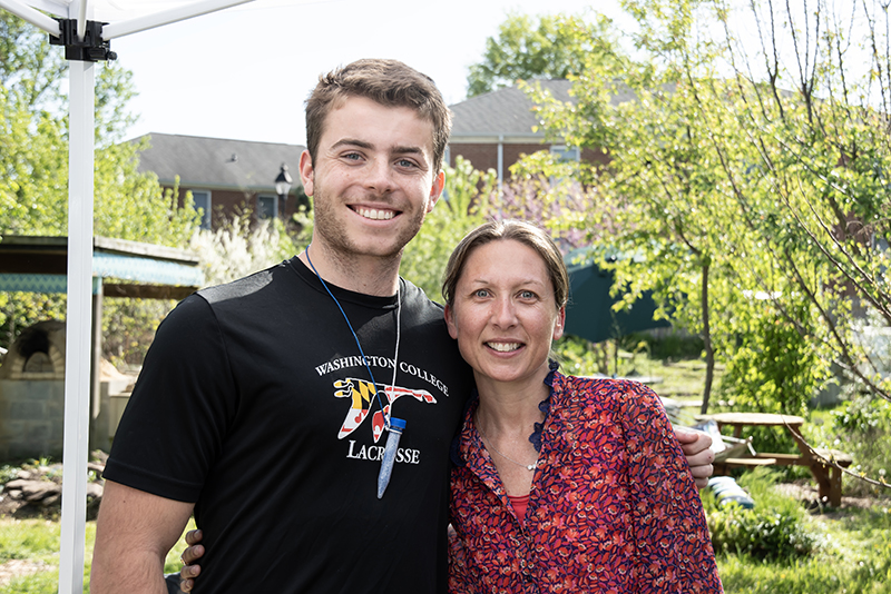 Grant Thomas '24 and chemistry professor Anne Marteel-Parrish pose in the campus garden during the chemistry honor society induction ceremony