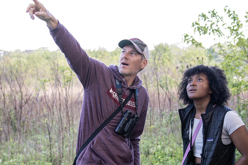 Dan Small (left) points out a bird to a Washington College student during a bird walk.