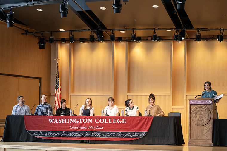 Students appear on stage during the Presidential Symposium during the first panel on artificial intelligence.