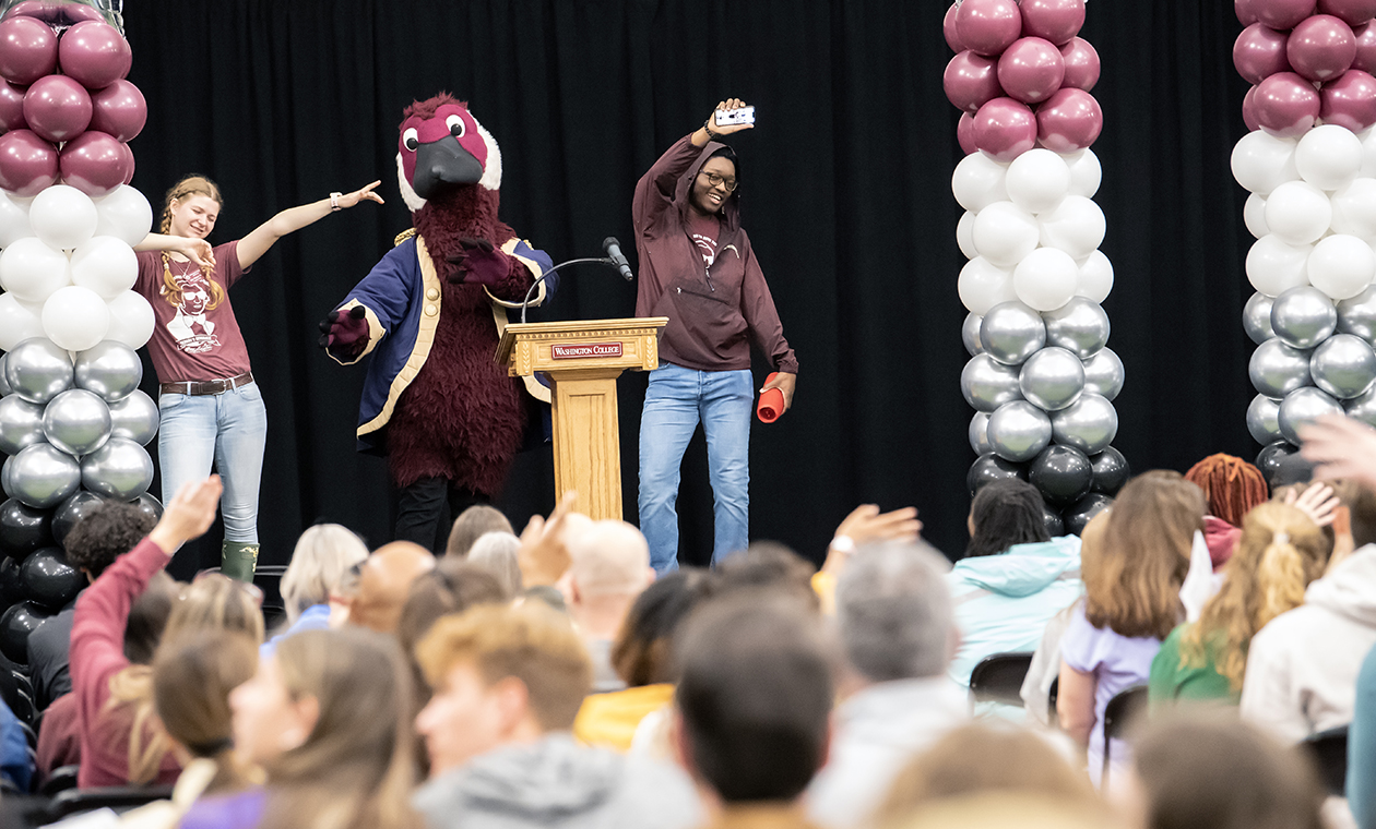 a crowd at Admitted Student Day watches students and Gus the Goose on stage