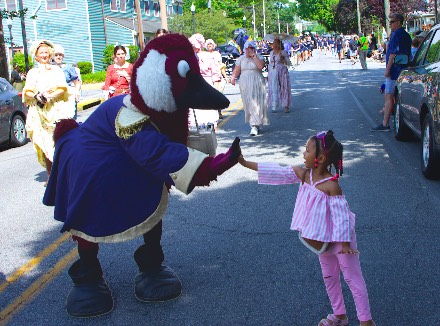Gus the Goose gives a girl a high five along the Chestertown Tea Party parade route