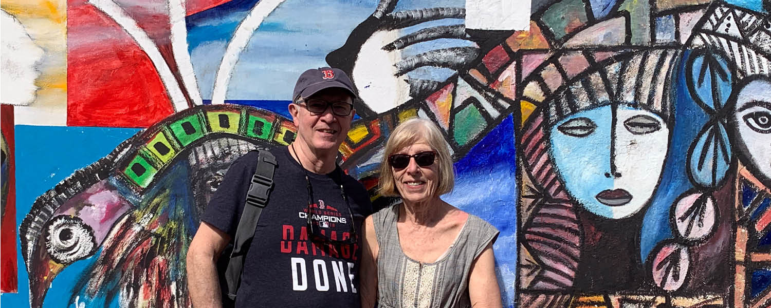 A couple standing in front of mural