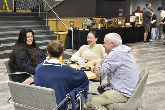 students with parents around table laughing