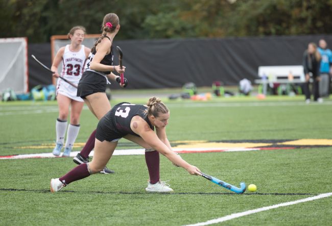 girl playing field hockey