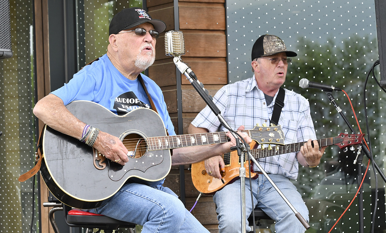 Two guitar players sing at the boathouse