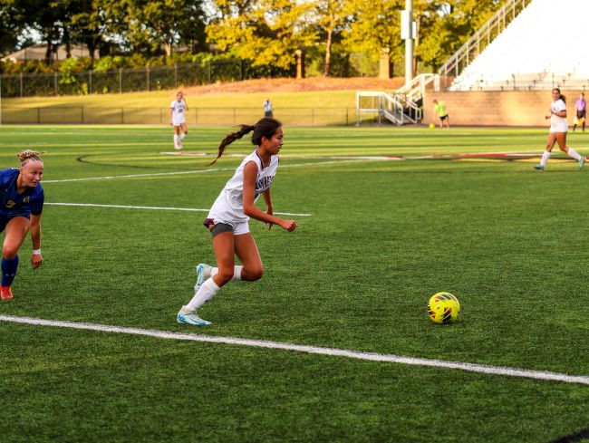 women's soccer player kicking a ball