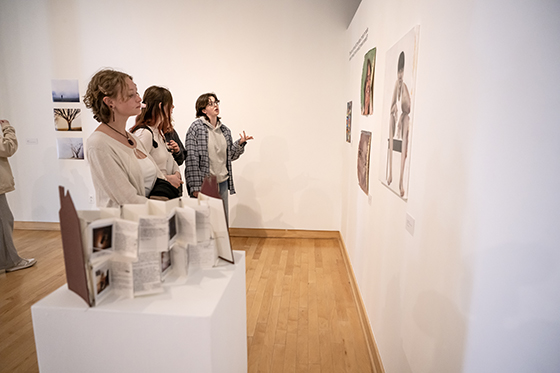 Students look at art in Kohl Gallery during 100 Proof, the juried student work exhibit