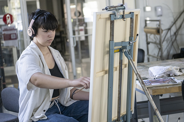 A student painting at an easel