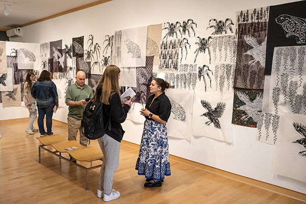 A student talking about her art capstone exhibit in Kohl Gallery