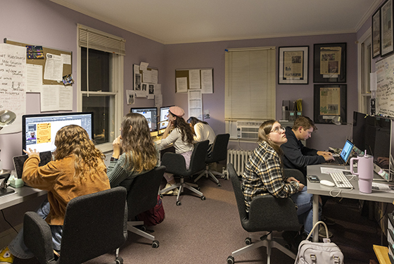 Students work on The Elm at multiple computers in one room at the Publications House