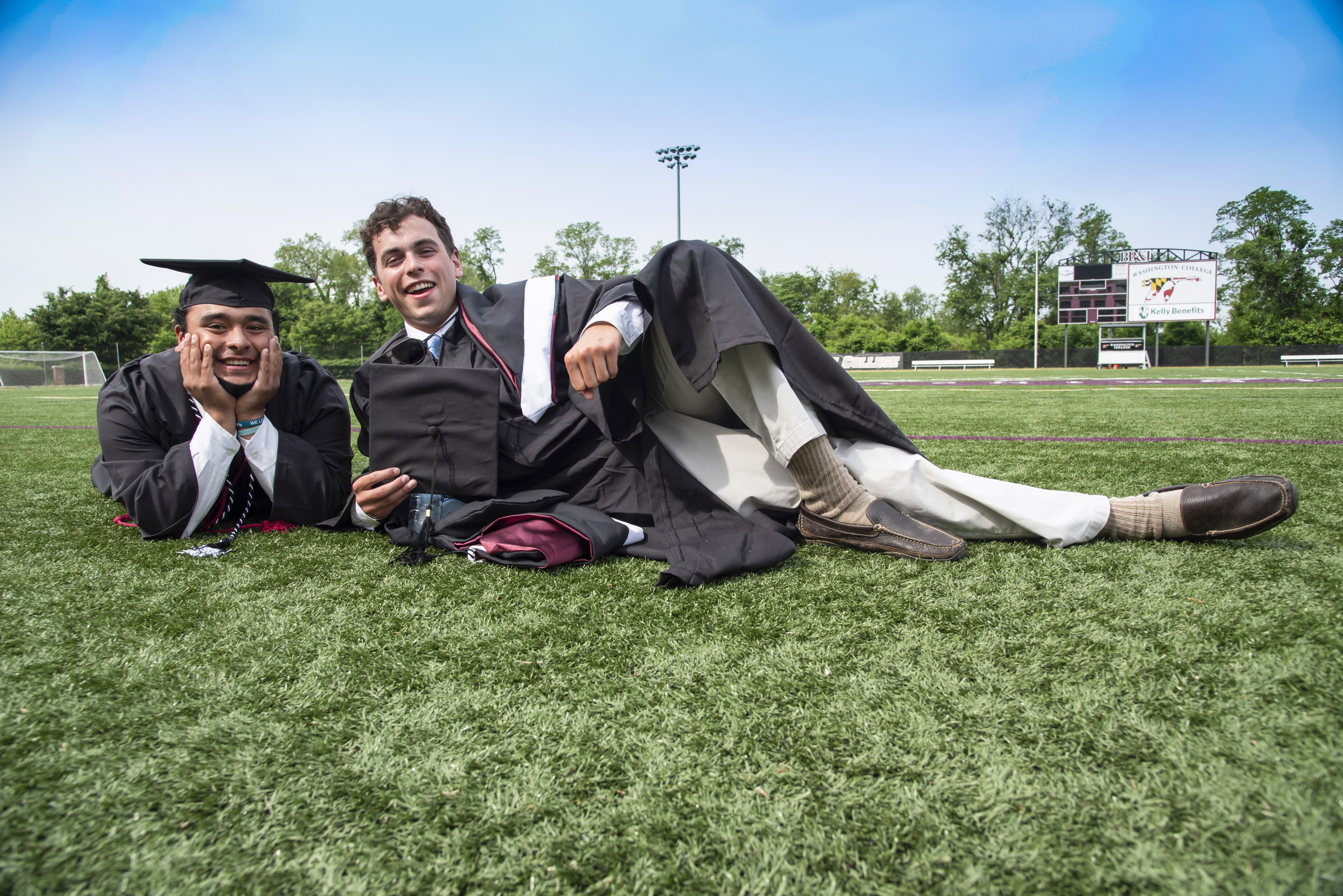 graduates laying on lawn