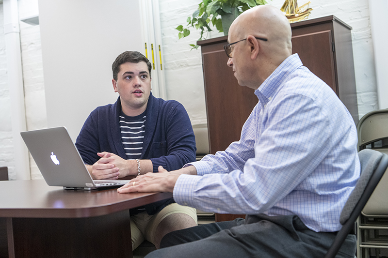 a student and staff member meet