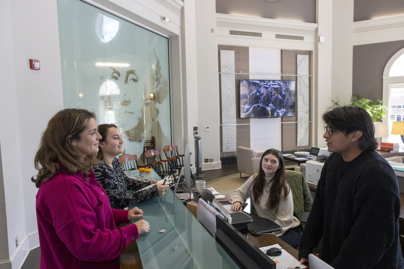 Students help people at the Visitors' Center desk