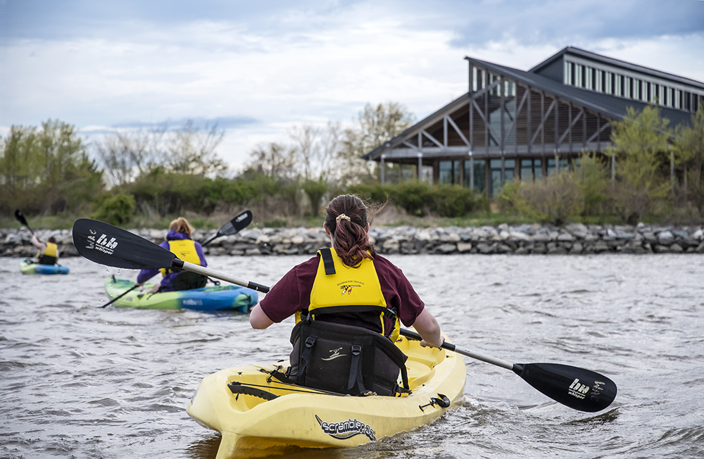 students kayak infront of semans-griswold environmental hall