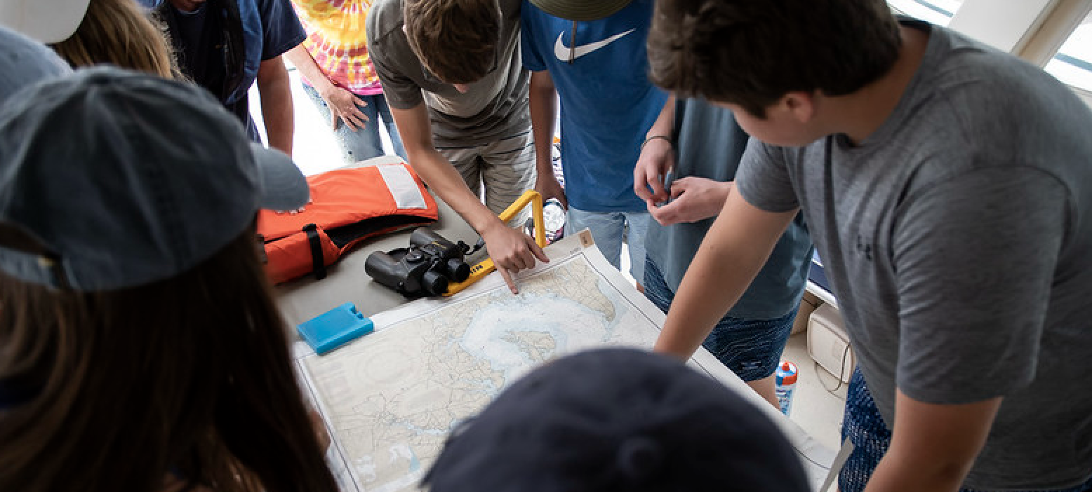 Students on boat looking at map