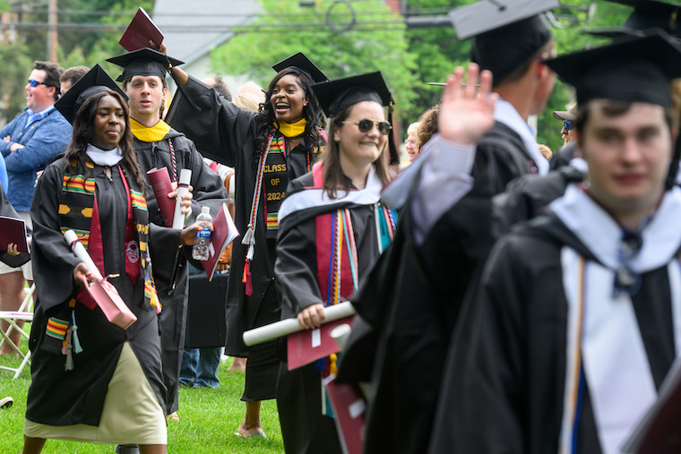 Students wave to friends and family after the commencement ceremony