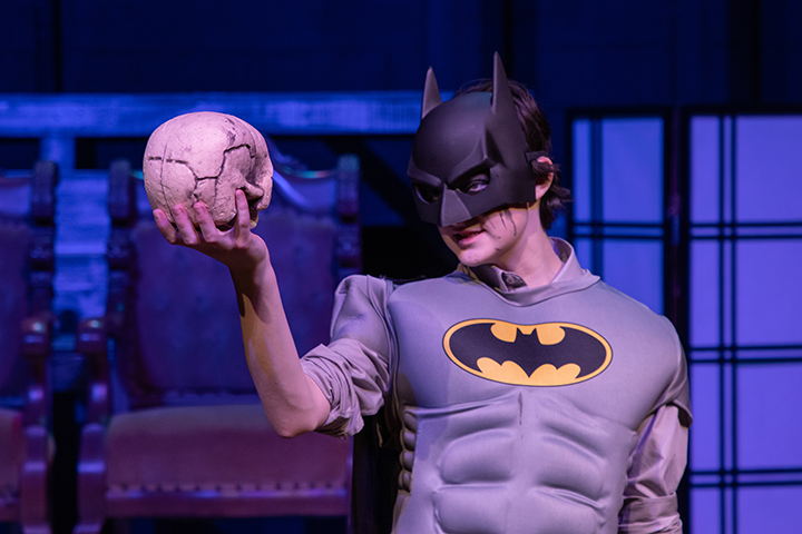 Costumed Batman holds skull during iconic Hamlet scene