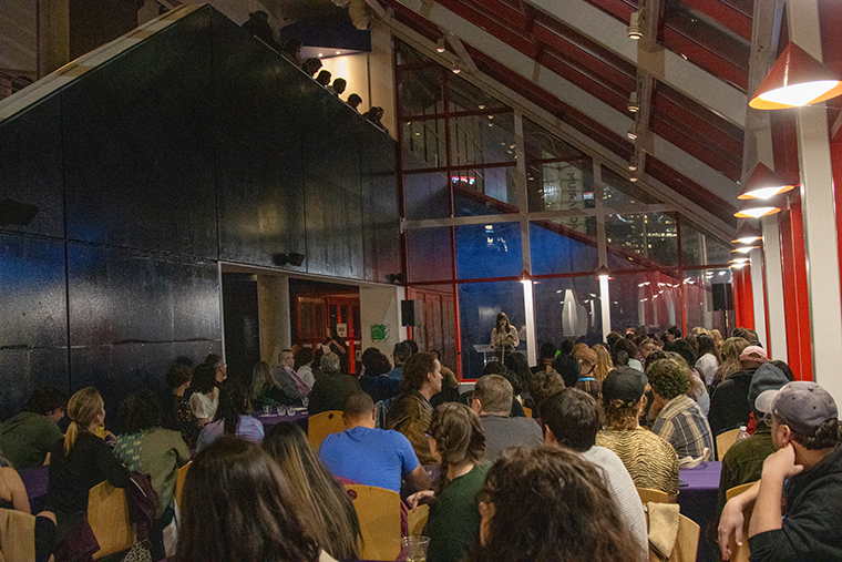Listeners fill a room at the National Aquarium to listen to a reading