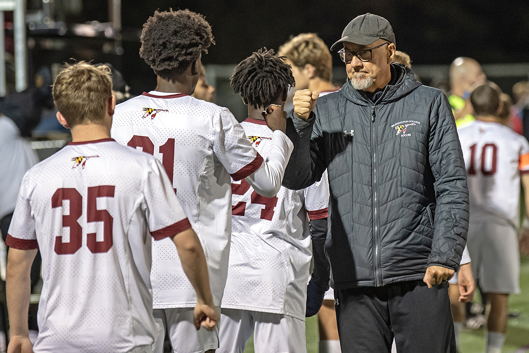 Head Coach Roy Dunshee fistbumps his players on the sidelines.