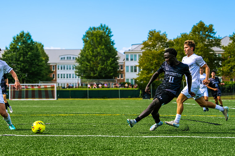 Tshazi Kamau kicks the ball during a men's soccer game