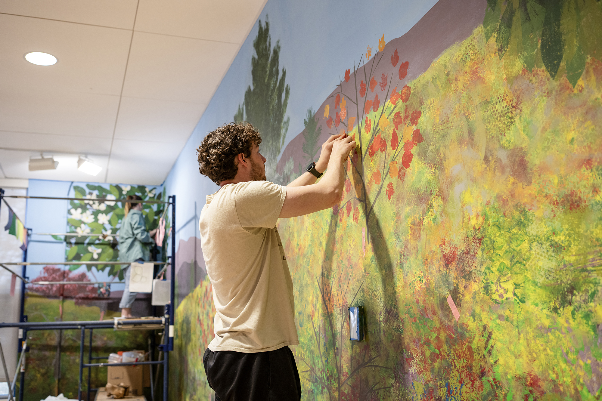 student painting a mural