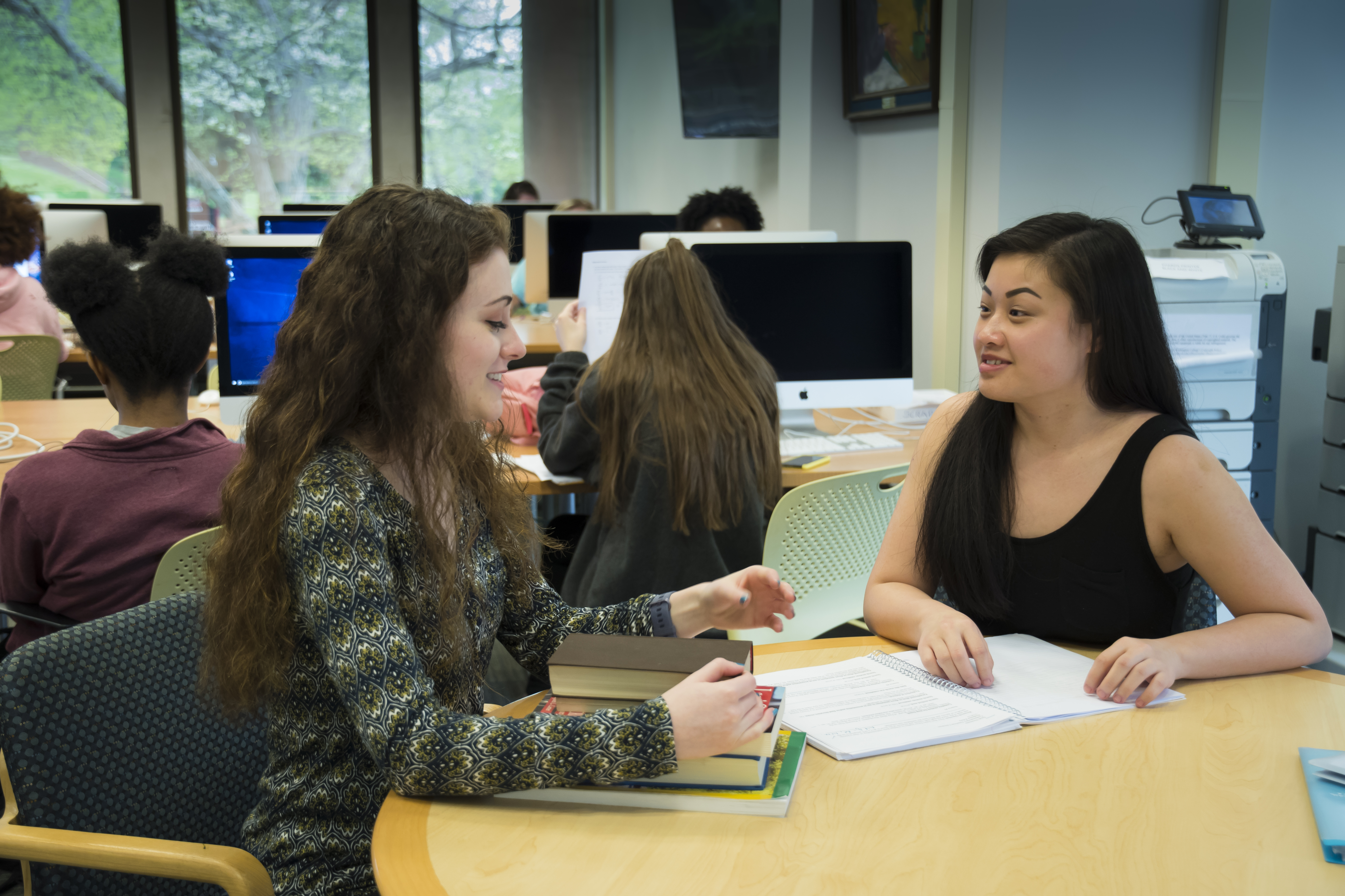 Two female students sitting at a table with homework