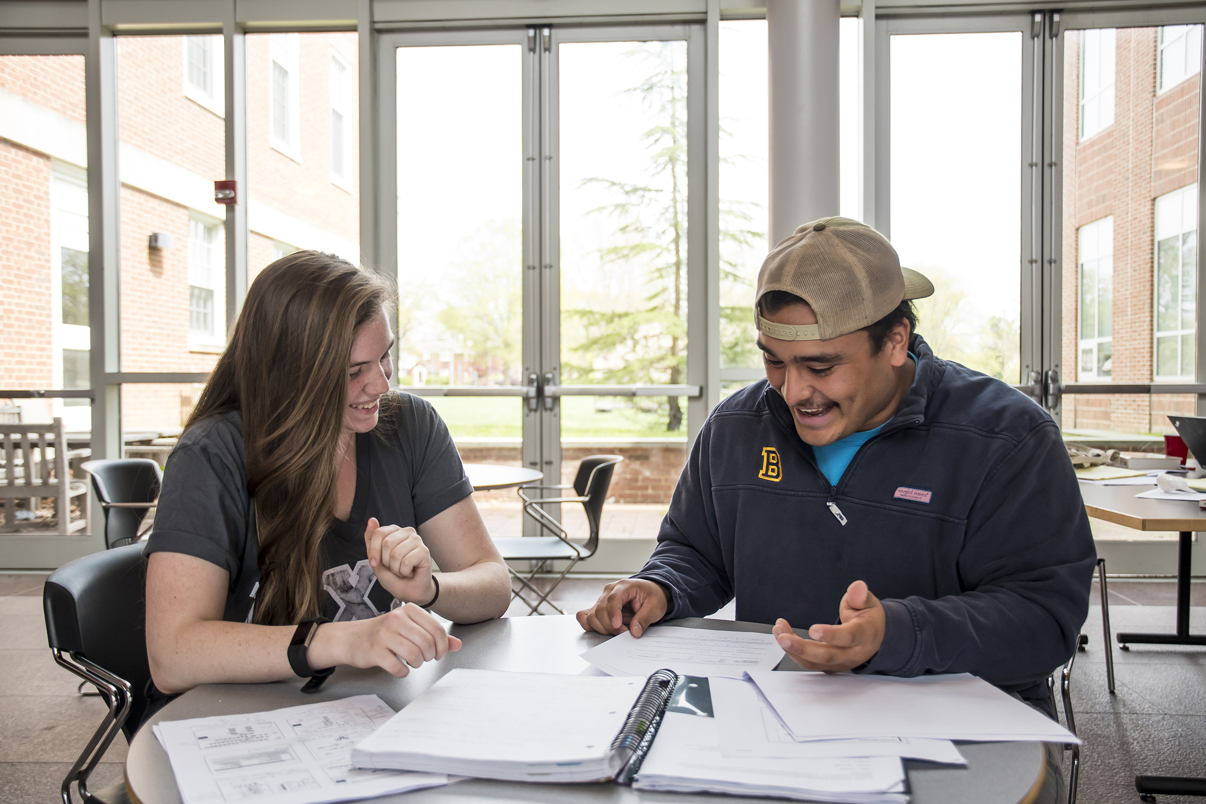 Two students sitting at a table with homework