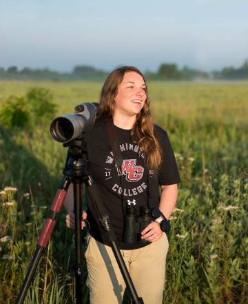 Sarah Polo photographing birds in grasslands