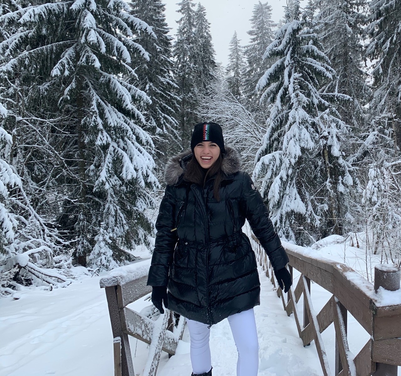 Jelisaveta, smiling and wearing a coat and hat in the snow. 